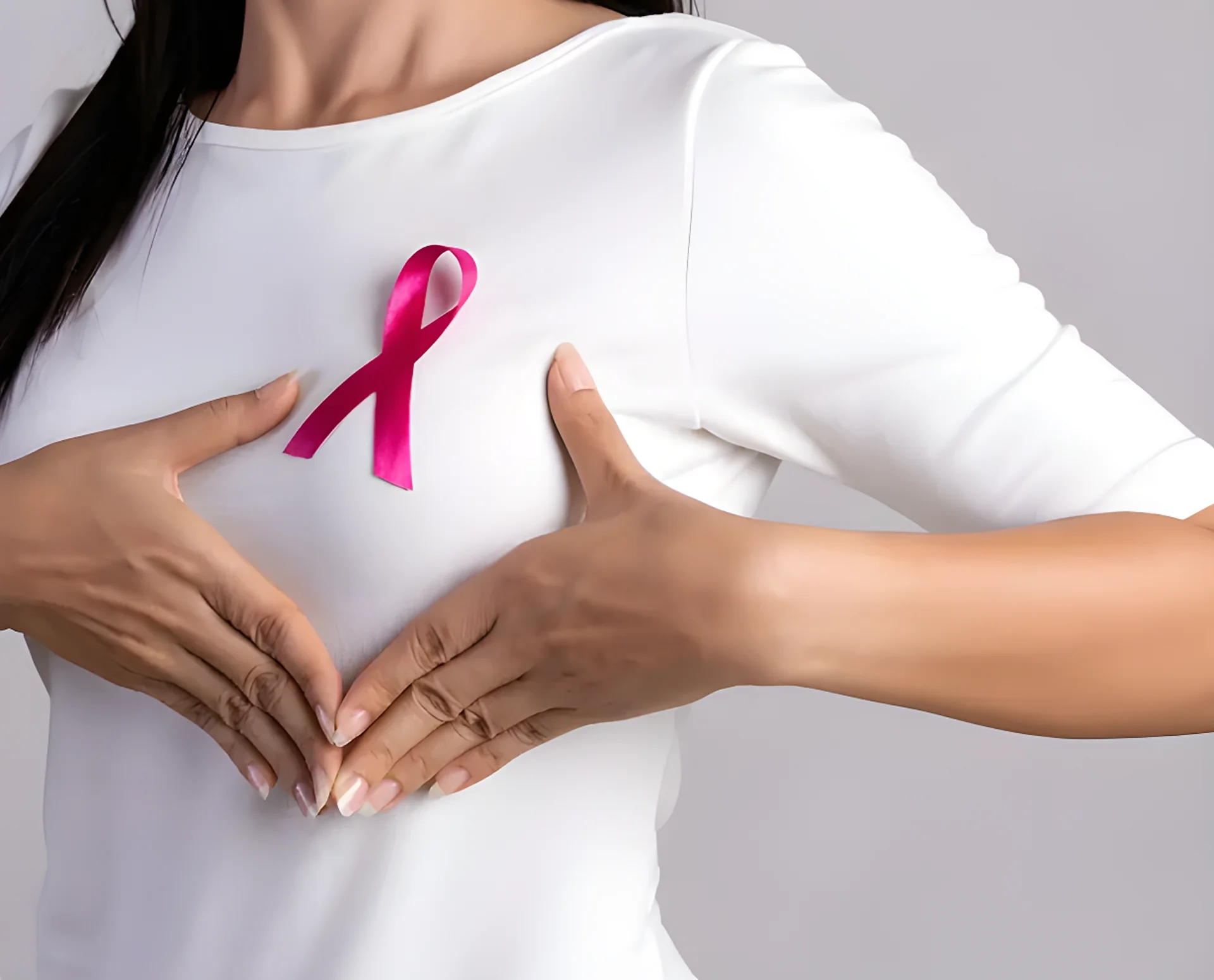 Woman wearing a white t-shirt with a pink breast cancer awareness ribbon