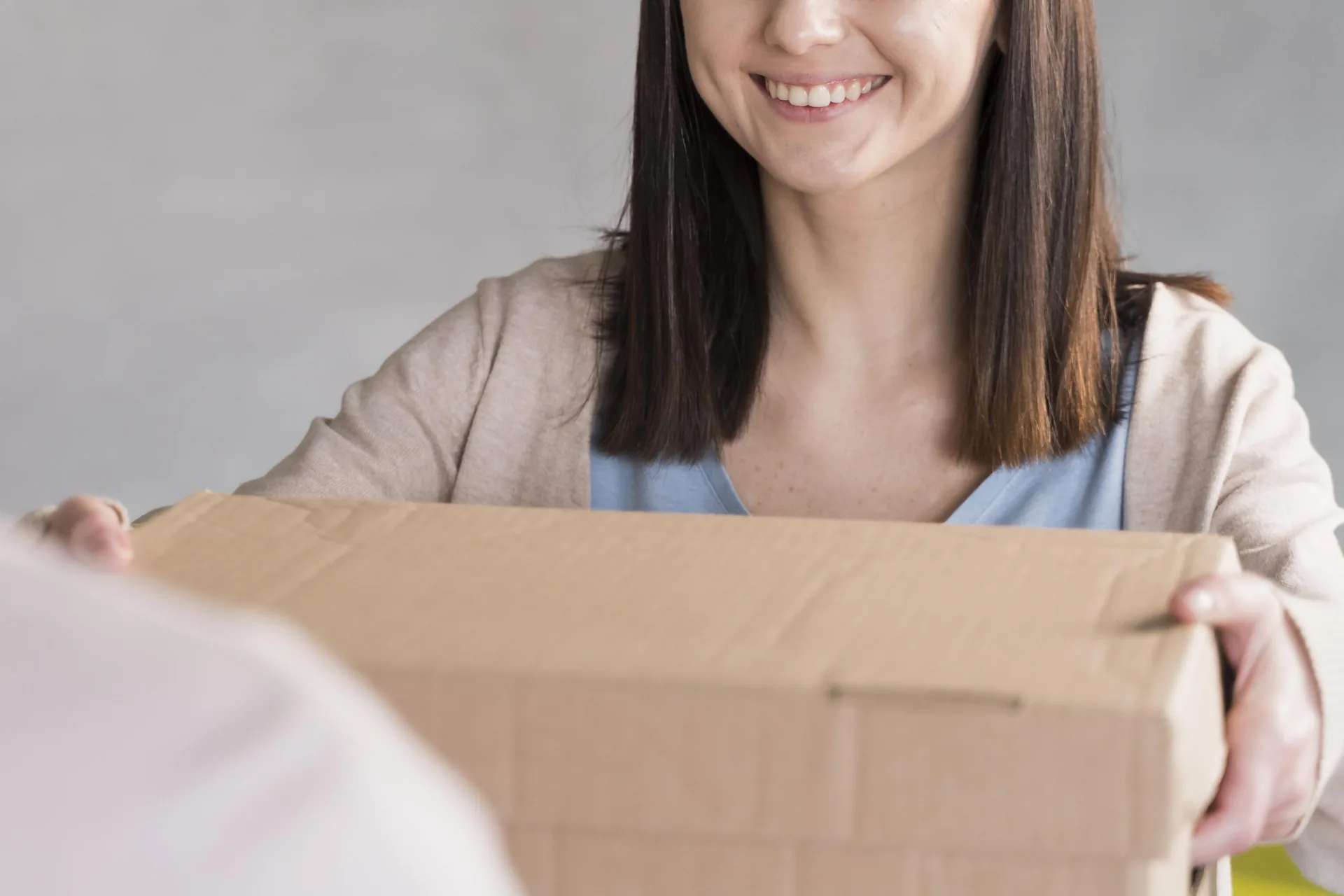 Person handing over a parcel of donated bras at the door